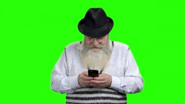 Yeşil ekranda cep telefonu kullanan kıdemli adam.