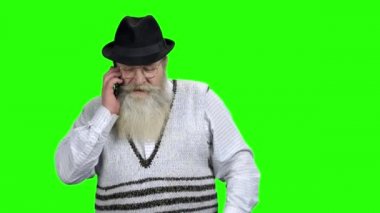 Cep telefonuyla konuşan yaşlı bir adam..