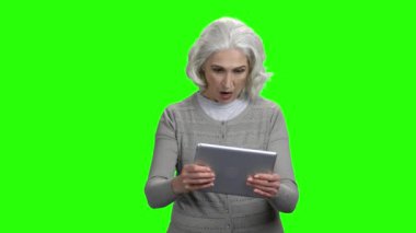Bilgisayar tabletinde oyun oynayan yaşlı kadın.