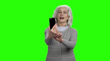 Üst düzey beyaz kadın telefonla selfie çekiyor.