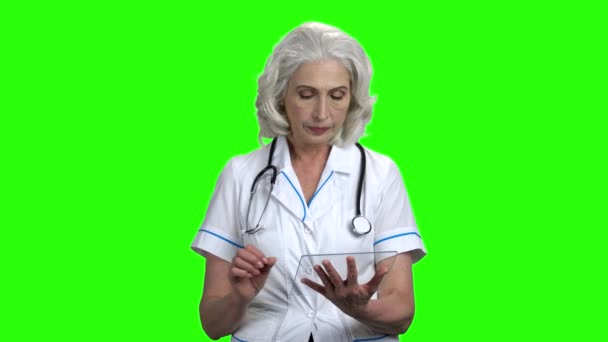 Ηλικιωμένος γιατρός χρησιμοποιώντας γυαλί δισκίο σε πράσινη οθόνη. — Αρχείο Βίντεο