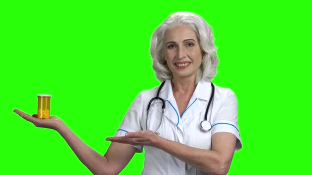 Elderly woman doctor holding jar of pills. — Stock Video