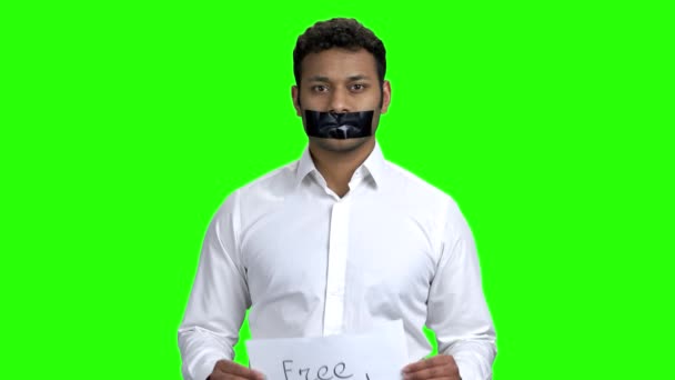 Dark-skinned man with black tape over mouth. — Stock Video