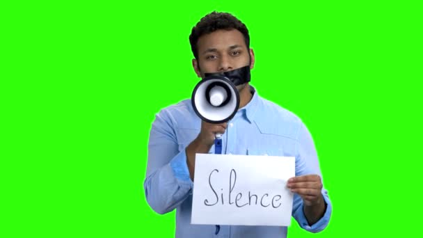 Hombre con cinta en la boca sosteniendo megáfono. — Vídeos de Stock