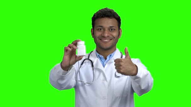 Erkek doktor hapları gösteriyor ve başparmağını kaldırıyor. — Stok video