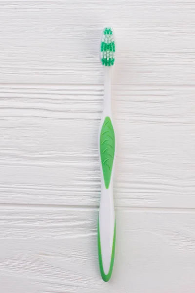 Green tooth brush on white wooden background. — Stock Photo, Image