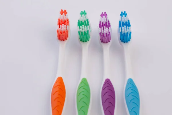 Vier farbige Zahnbürsten auf weißem Hintergrund. — Stockfoto