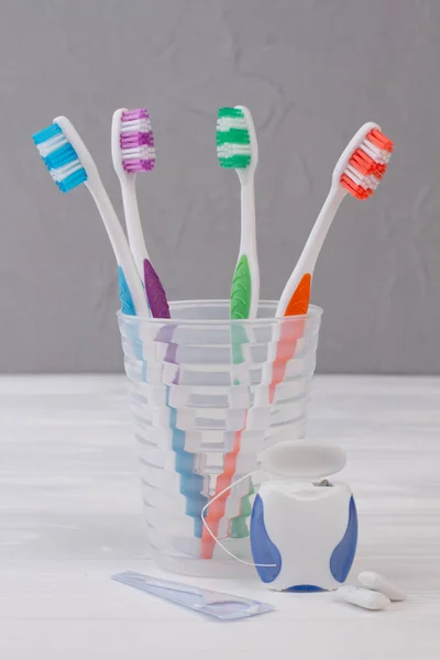 Toothbrush in glass, dental floss and chewing gums. — Stock Photo, Image