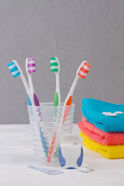 Toothbrush in glass, dental floss, towels and chewing gums. — Stock Photo, Image