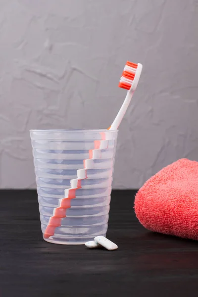 Glass with toothbrush, towel and chewing gums. — Stock Photo, Image