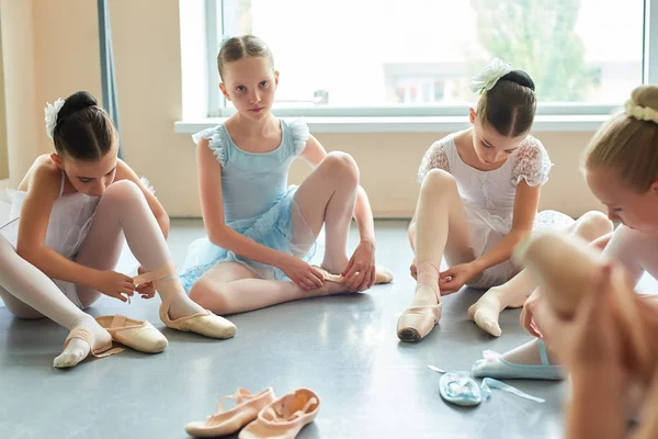 Jonge ballerina zittend op de vloer en kijken naar camera. — Stockfoto