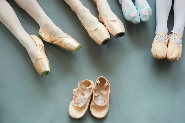 Ноги молодых балерин на сером фоне . — стоковое фото