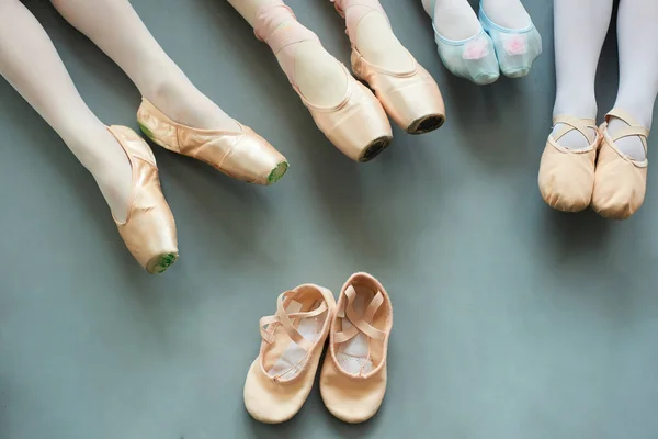 Piernas de bailarinas jóvenes sobre fondo gris . — Foto de Stock