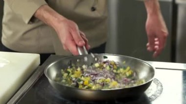 Şef bir tavada yemek çevirmek.