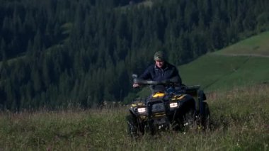 Two men riding quad bikes in the mountains.