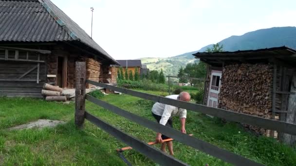 Old man mowing the grass with scythe. — Stock Video