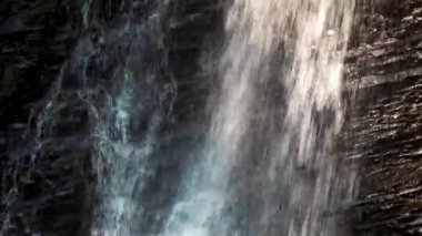 Güneşli bir günde küçük kayalık dağ şelalesi.