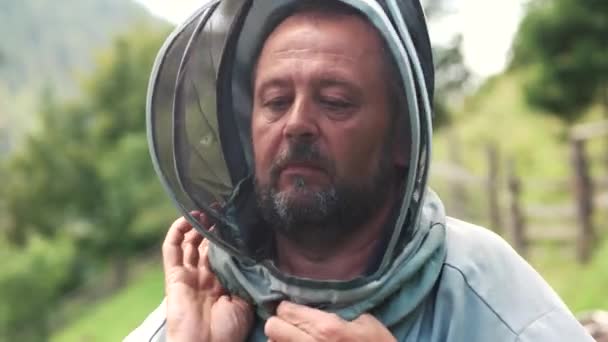 メッシュフェイスマスク付きスーツを着用した養蜂家. — ストック動画
