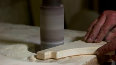 Hands of carpenter working with wooden plank.