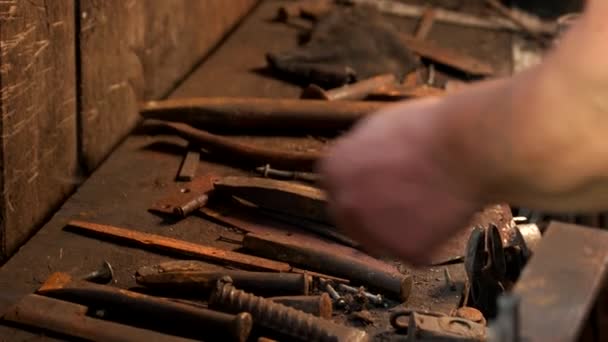 Metal tools of blacksmith are on the tabe. — Stock Video