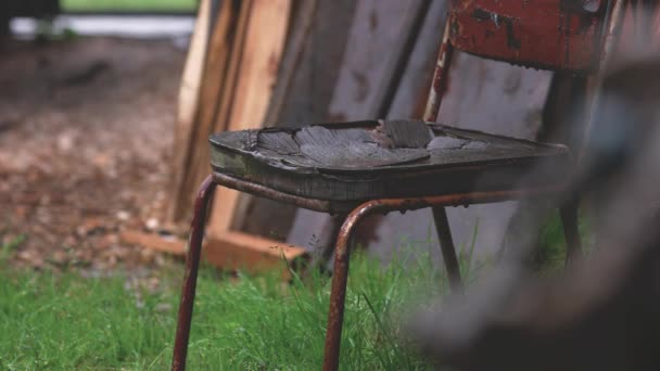 Rain falling on old chair. — Stock Video