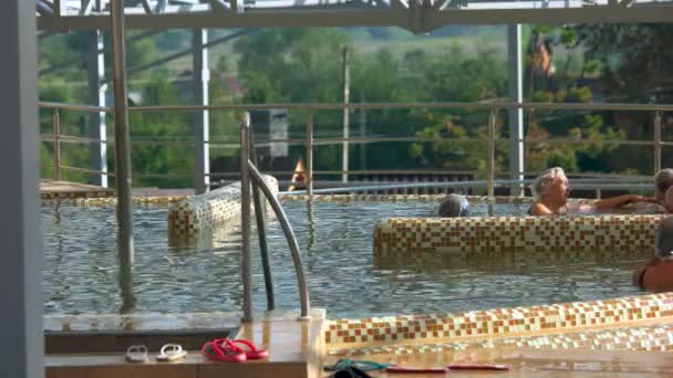 Pessoas relaxando na piscina exterior com água termal . — Vídeo de Stock