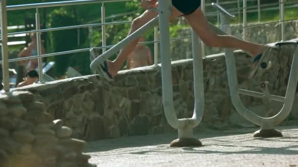 Homem se exercitando em equipamentos de ginásio ao ar livre . — Vídeo de Stock