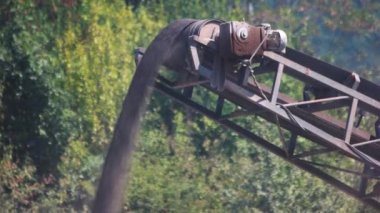 Güneşli bir günde çalışan çakıl ile bantlı konveyör.