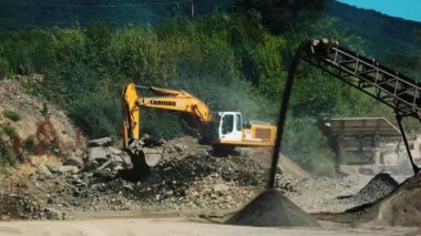 Granit ocağında çalışan ekskavatör kazıcı.