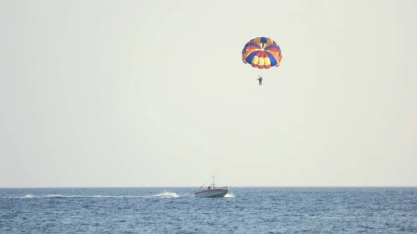Couple of tourists flying with parachute over the sea. — Stock Photo, Image