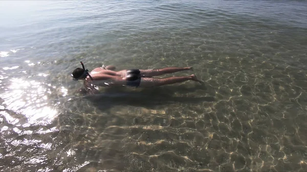 Чоловік у воді плаває у воді на пляжі . — стокове фото