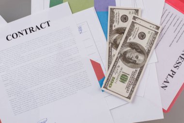 İmzalanmış kontrat ve dolar banknotları.