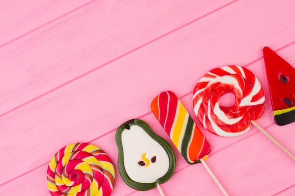 Different lollipops on color wooden background. — Stock Photo, Image
