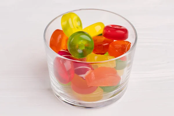 A transparent glass filled with colorful candies. Stock Photo