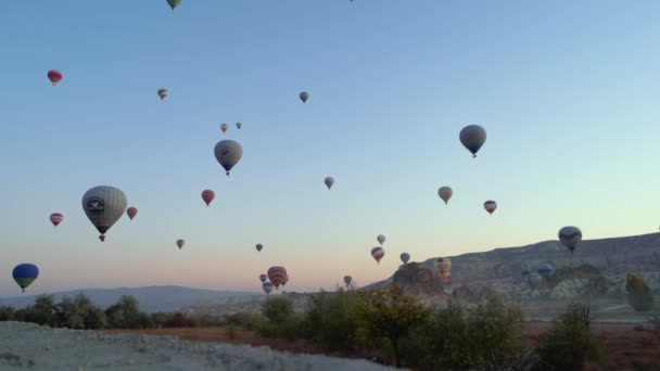 Hot air balloons flying over rocky mountains. — Stock Video