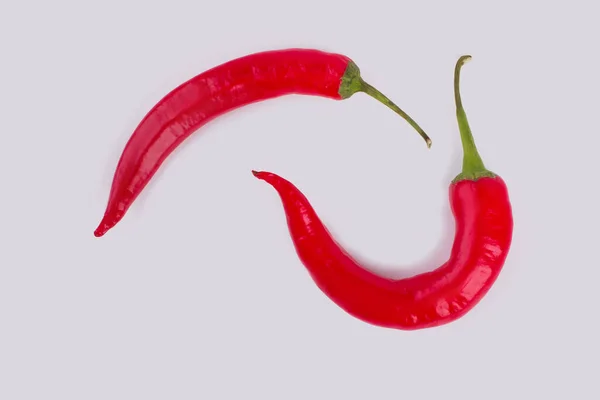 Duas pimentas vermelhas de pimentão quente isoladas em branco . — Fotografia de Stock