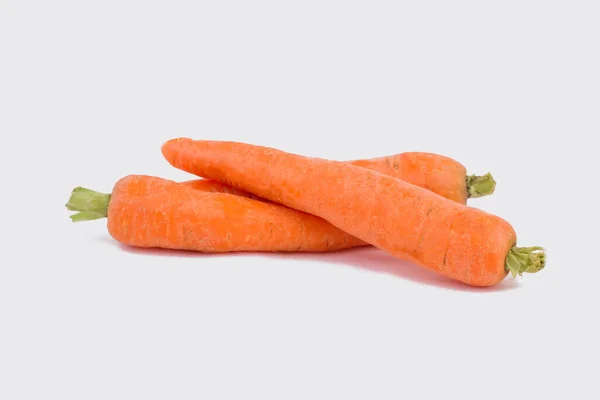 Bunte orangefarbene Karotten auf weißem Grund. — Stockfoto