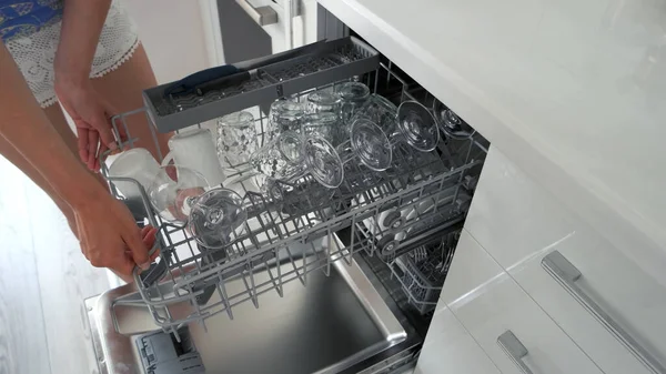 Young housewife taking out dishes from dishwasher. — Stock Photo, Image