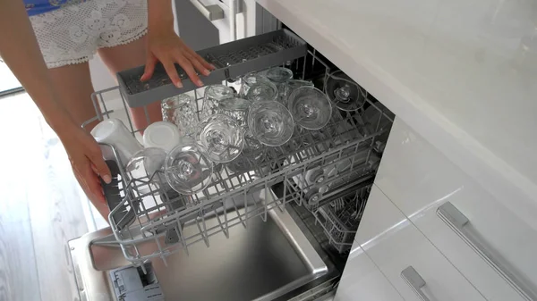 Mujer joven usando lavavajillas en la cocina . —  Fotos de Stock