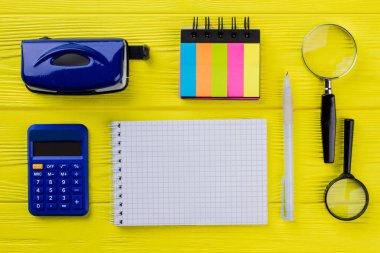 Kopya alanı için boş not defteri ve sarı ahşap masadaki eski ofis aksesuarları.