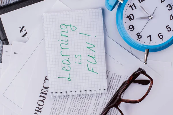 Learning is fun note with spectacles and alarm clock.