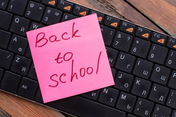 Adesivo nota con torna a scuola calligrafia su una tastiera del pc. — Foto Stock