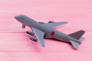 Düz oyuncak uçak pembe ahşap arka planda yatıyordu.