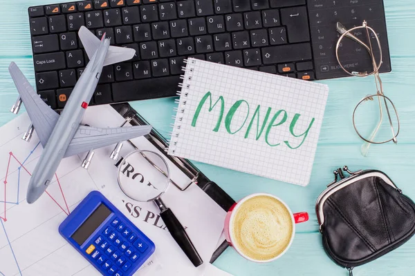 Dinero en cuaderno con accesorios de viajero gafas billetera y avión sobre fondo de mesa de madera . —  Fotos de Stock