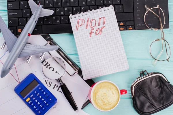 Planes 2019 en notebook con accesorios de viajero billetera gafas y avión sobre fondo de mesa de madera . —  Fotos de Stock