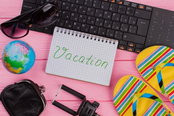 Urlaub auf dem Notizbuch mit Frauen-Reiseaccessoires Brille Brieftasche und Flip-Flops auf rosa Tischplatte Hintergrund. — Stockfoto