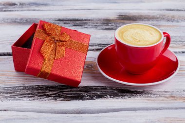 Kırmızı hediye kutusu ve köpüklü kahve..