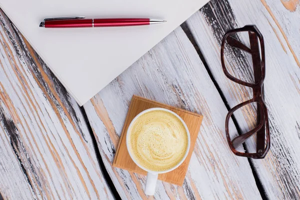 Coucher plat tasse de café avec verres et stylo. — Photo