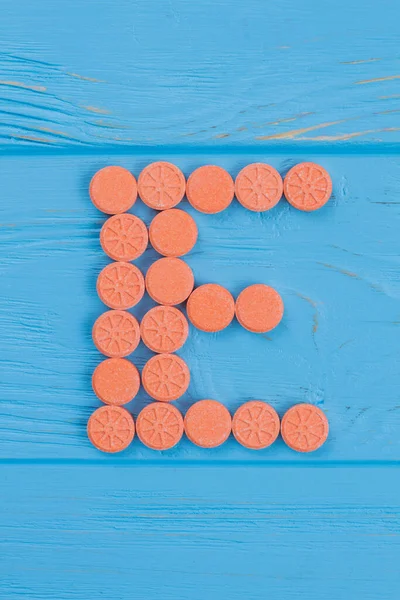 Carta E feita de drogas laranja redondas . — Fotografia de Stock