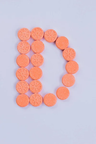 Буква D сделана из круглых таблеток . — стоковое фото